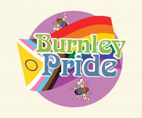 Round logo with the words Burnley Pride in large text on top of a purple circle and the LGBT+ flag.